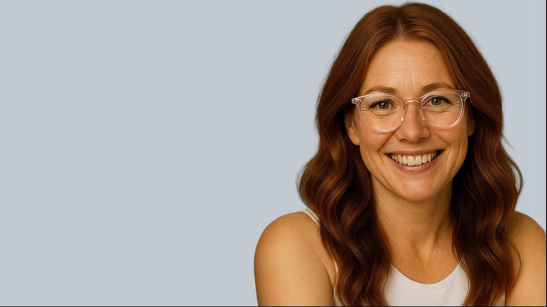 Woman with glasses smiling against a light blue background